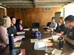 photo os students at a table discussing a book